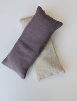 Two Lavender Linen Eye Pillows—one purple, one beige—filled with organic flaxseed rest on a white surface.
