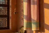 Sunlight streams on Sunrise Fair Trade Block Printed Linen by a lattice window; a brass lamp glows nearby.