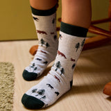Child wearing light-colored Kids Socks that Protect Bears with a pattern of bears and pine trees.