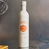A white bottle of Algae Cooking Oil sits on a counter, surrounded by various kitchen utensils.