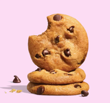 Three Chewy Chocolate Chip Cookies stacked on pink, one bitten—made with artisan red wheat flour.