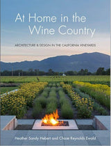 Book cover: At Home in the Wine Country—vineyard, mountains, modern farmhouse & fire pit at sunset in California. The subtitle reads "Architecture & Design in the California Vineyards'