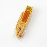 A California Biscotti - Single, crafted in California with roasted almonds, is individually wrapped in clear plastic with a yellow and orange label reading “Biscotti Traditional Almond,” displayed on a white background.