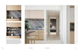 Modern kitchen with light wood cabinets and marble accents.