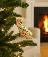 Embroidered ornament in the shape of California with California Poppy floral designs, displayed on a Christmas tree