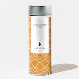 A canister of Caramelized Pear Loose Leaf Tea, caffeine free, with gold geometric pattern and silver lid on white.