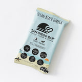 The San Diego Bar Ocean Beach Omega San Diego Snack Bar features a beach-themed design with a van and palm trees, and icons for raw vegan, plant-based, gluten-free, rich in omegas, no added sugar, and all natural ingredients.