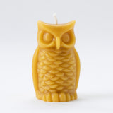 The Owl Beeswax Candle is a hand-poured, owl-shaped candle with detailed feathers, eyes, and beak. It stands upright on a white background and naturally purifies the air—an adorable addition to your space.