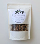 A clear, resealable bag of Rancho La Vina Organic Walnuts, original flavor, featuring a white label with the brand name, product details, and an illustration of walnut branches.