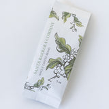 A white packet labeled SBCO Coffee, 5 oz, with illustrated green leaves and coffee berries on the packaging—proudly offering organic Santa Barbara coffee.