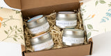 The Santa Barbara Coastal Candle Gift Set features four soy wax travel candles—Hendry’s Beach, Miramar Beach, Butterfly Beach, and Goleta Bluffs—in an open box with floral inner flaps and shredded paper packing.