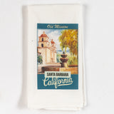 The Santa Barbara Mission Kitchen Towel is a white cotton dish towel with an illustration of Old Mission Santa Barbara, including the fountain and trees, plus "Old Mission Santa Barbara California" text—a charming addition to any kitchen.
