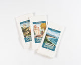 The Santa Barbara Mission Kitchen Towel features colorful vintage-style illustrations and text referencing Santa Barbara landmarks like the Courthouse, Old Mission, and Stearns Wharf. Made of white cotton for a stylish kitchen accent.