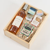 The Santa Barbara Rosé Gift Box includes a bottle of rosé, organic pistachios, cookies, a small candle, soap, and a watercolor notepad—artfully arranged in a wood box for a delightful California gourmet gift.
