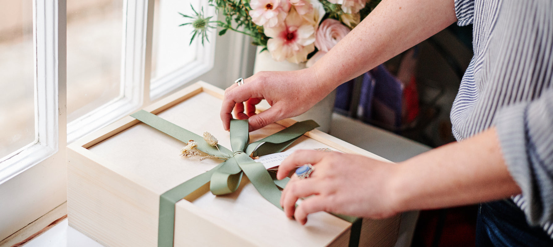 gift box being tied up with ribbon