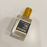 Sunset Noir Perfume Oil in a small glass roll-on bottle with a gold cap, set against a dark background.