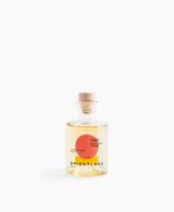 A clear glass bottle of Citrus Champagne Vinegar with a wooden stopper and a minimalist label.