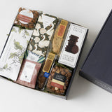 Coffee Pairings Gift Box: Assorted snacks, cookies, chocolate, almonds, tea & biscotti in decorative packaging.