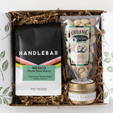 Handlebar Coffee Break Gift Box with organic pistachios and a soy candle, arranged on shredded brown paper.