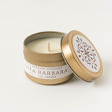 Santa Barbara Travel Candle in gold tin with lid off reveals white wax; floral fragrance label reads "Santa Barbara.