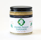 A 4 oz glass jar of Artichoke and Parmesan Tapenade with a black lid and a white label featuring a green artichoke—ideal as an appetizer spread with rich parmesan cheese flavor.