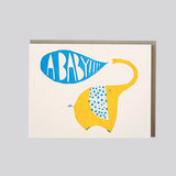 A Baby!! greeting card featuring a yellow elephant with a blue polka-dot ear and a speech bubble saying A BABY!!!.