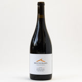 A bottle of Brick Barn Red Rhone Blend wine with a white label and minimalist orange design, set against a plain white background.