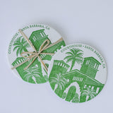 The Courthouse of Santa Barbara Letterpress Coasters are round cotton coasters with a green courthouse and palm trees design, "COURTHOUSE • SANTA BARBARA, CA" letterpressed around the edge, and one tied with raffia.