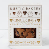 A box of Ginger Baby Cookies decorated with heart and gingerbread figure designs. The white package features gold and brown accents, and a clear window displays the festive holiday cookies inside.