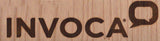 The image displays the Invoca Wood Box Brand name in bold, uppercase dark brown letters beside a speech bubble icon, all set on a light wooden background.