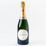 A bottle of Laurent-Perrier La Cuvee Brut Champagne, featuring a gold foil top and white label, stands upright on a plain white background.