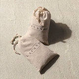 Two small beige Lavender Sachet bags with drawstrings rest on a light textured surface. Each is labeled "LAVANDE" in black, indicating they contain natural lavender.
