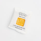 A white packet labeled Meyer Lemon Shortbread Cookie displays a photo of a golden, square cookie in the center, presenting these Northern California treats on a plain white background.
