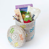 The Organic California Baby Gift Basket features a woven, lidded basket filled with an organic cotton onesie, Good Night California book, baby lotion, plush toy, and dried flowers—a charming gift to welcome little ones.