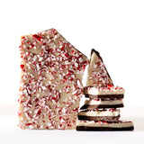 Peppermint Candy Chocolate Bark features layers of white and dark chocolate, topped with peppermint candy pieces and styled against a crisp white background.