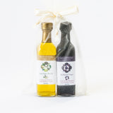 The Petite Olive Oil and Fig Balsamic Vinegar Set includes two small bottles, elegantly labeled with Santa Barbara Company, packaged in a sheer white organza gift bag tied with a ribbon.