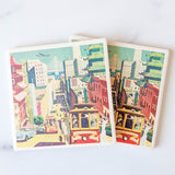 San Francisco Travel Poster Coasters: Set of two vibrant stone coasters showcasing a vintage city scene with cable cars, pagoda rooftops, classic cars, and the Bay Bridge—perfect square drink coasters for San Francisco fans.