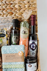 The Santa Barbara Soups basket includes a bottle of olive oil, dried lentil curry, fig balsamic vinegar, patterned cloth napkins, and organic pistachios.
