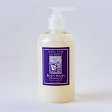 Santa Ynez Lavender Body Wash comes in a clear plastic pump bottle with a purple label featuring lavender art. Infused with organic lavender, it gently cleanses and leaves a soothing floral scent. Displayed against a plain white background.