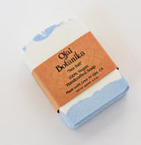 A rectangular bar of Sea Salt Ojai Botanika Soap with blue and white layers, wrapped in a brown paper label reading vegan cruelty-free soap, handcrafted with love in Ojai, CA.