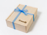 A light wooden SheerID Wood Box Brand gift box features "Sheer" engraved on the lid, tied with a sheer blue ribbon, displayed elegantly against a white background.