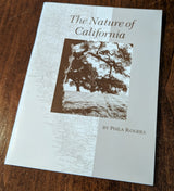 A booklet titled "The Nature of California" is displayed on a wooden surface, featuring a black-and-white photo of a tree with a map of California in the background.