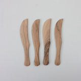 Four Walnut Wood Knives with curved blades are arranged vertically on a light gray background, highlighting the craftsmanship of Moroccan artisans.