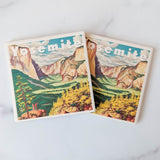 The Yosemite Travel Poster Coasters feature a vintage-style Yosemite Valley illustration with cliffs, trees, and blue sky. “Yosemite” in bold white letters tops each coaster, celebrating the beauty of Yosemite National Park.