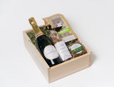 SheerID Anniversary Gift Box: champagne, organic popcorn, cookies, and herb almonds in a wooden box.