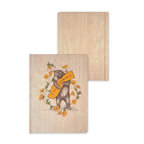 Two journals: one California Bear Hug design with florals and a banner, and one plain wooden notebook.