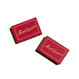 Two scarlet red Matchbox Merry Christmas boxes with gold-toned frames and script lettering.