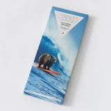 Chocolate bar packaging with a bear on a surfboard design on a white background