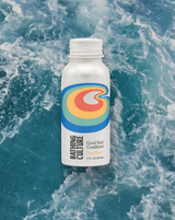 A white Good Seed Conditioner Travel Size bottle floats above swirling blue ocean waves.
