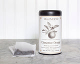 A tin of Cinnamon Orange Spiced Black Tea with biodegradable teabags sits on a marble surface.